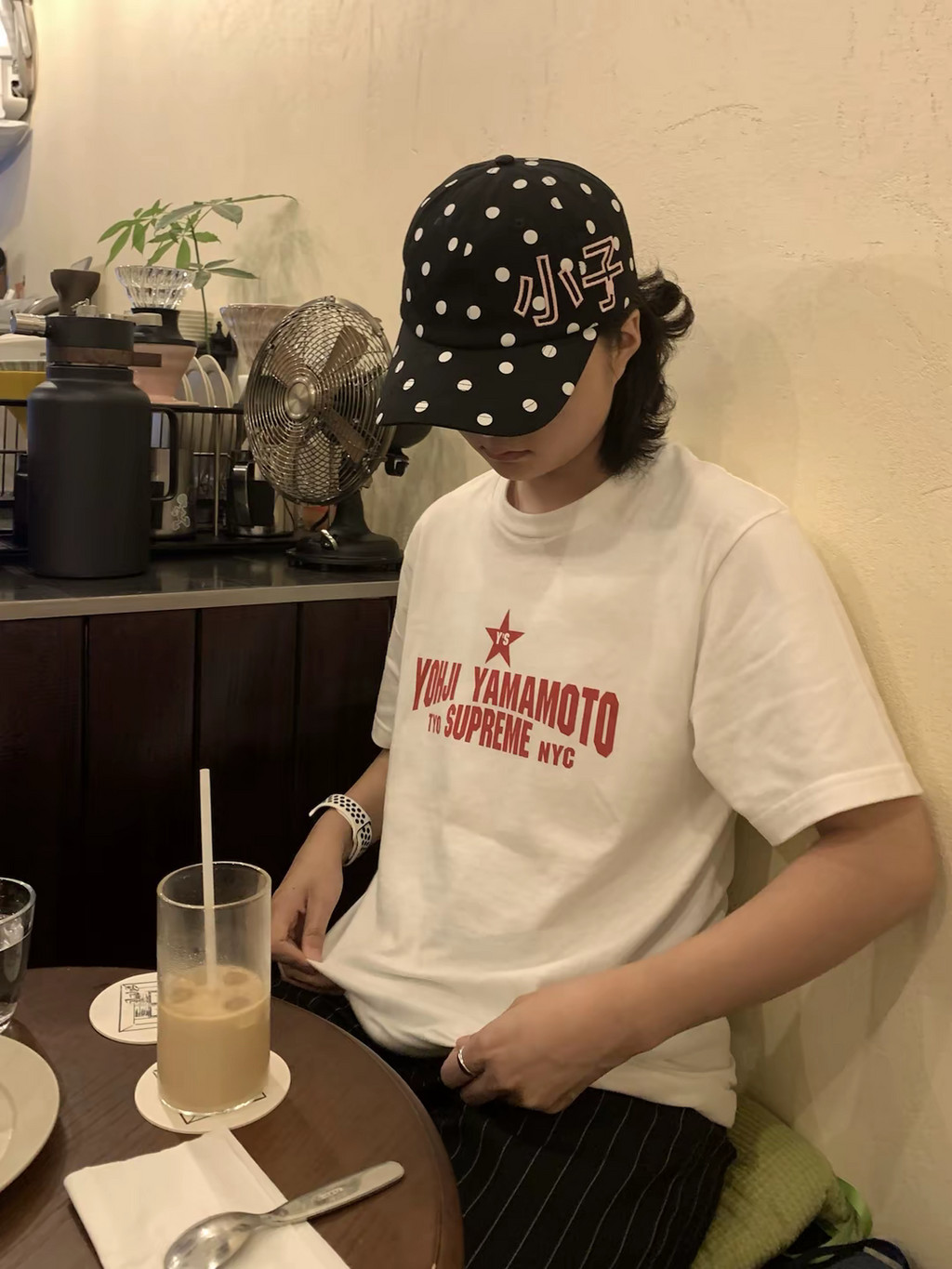White graphic T-shirt with red YOHJI YAMAMOTO logo print, worn with cap