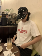 White graphic T-shirt with red YOHJI YAMAMOTO logo print, worn with cap