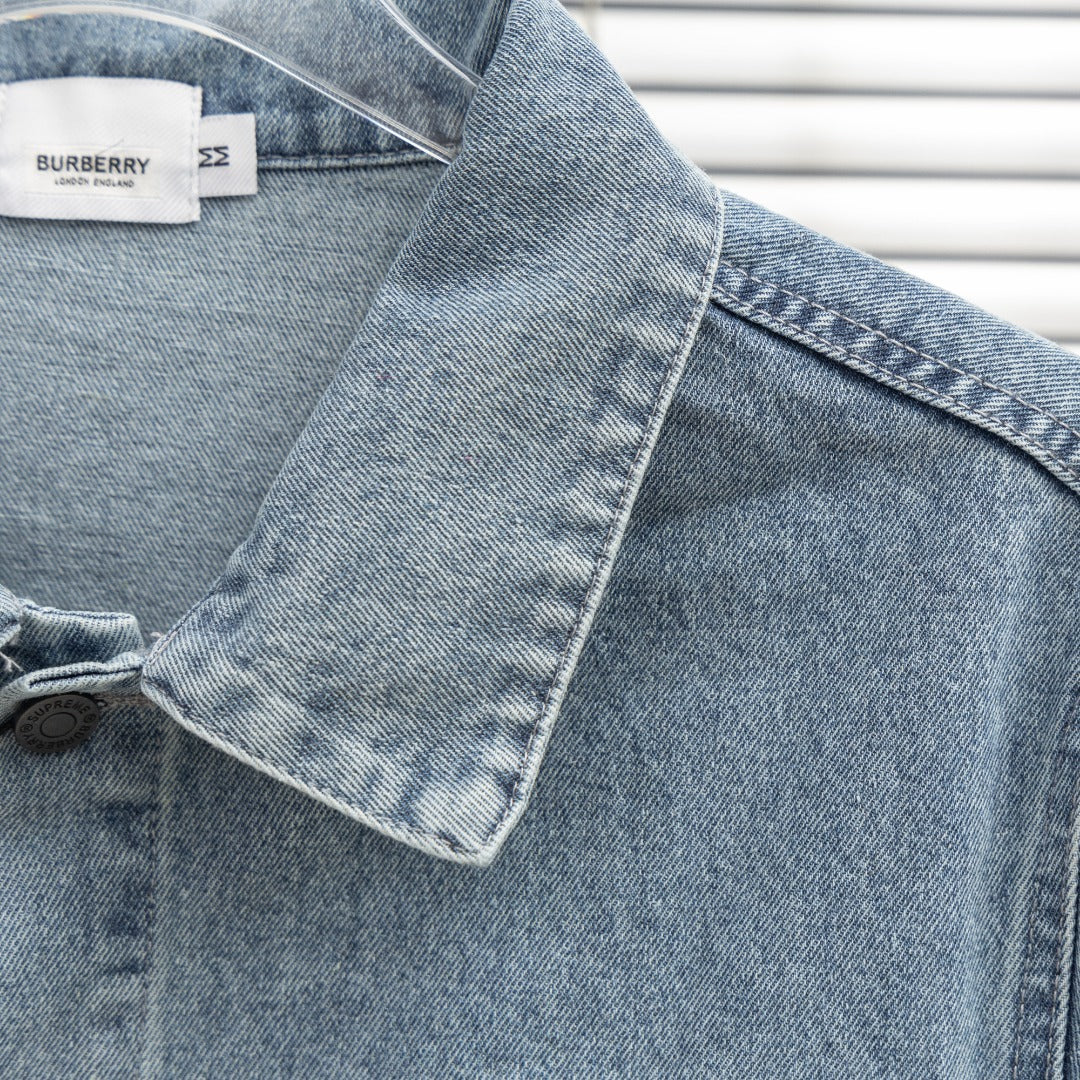 Denim jacket shoulder and collar close-up with seam details and buttoned placket