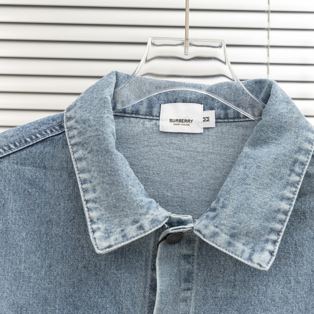 Denim jacket close-up with pointed collar, snap buttons, and small Burberry label