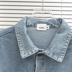 Denim jacket close-up with pointed collar, snap buttons, and small Burberry label