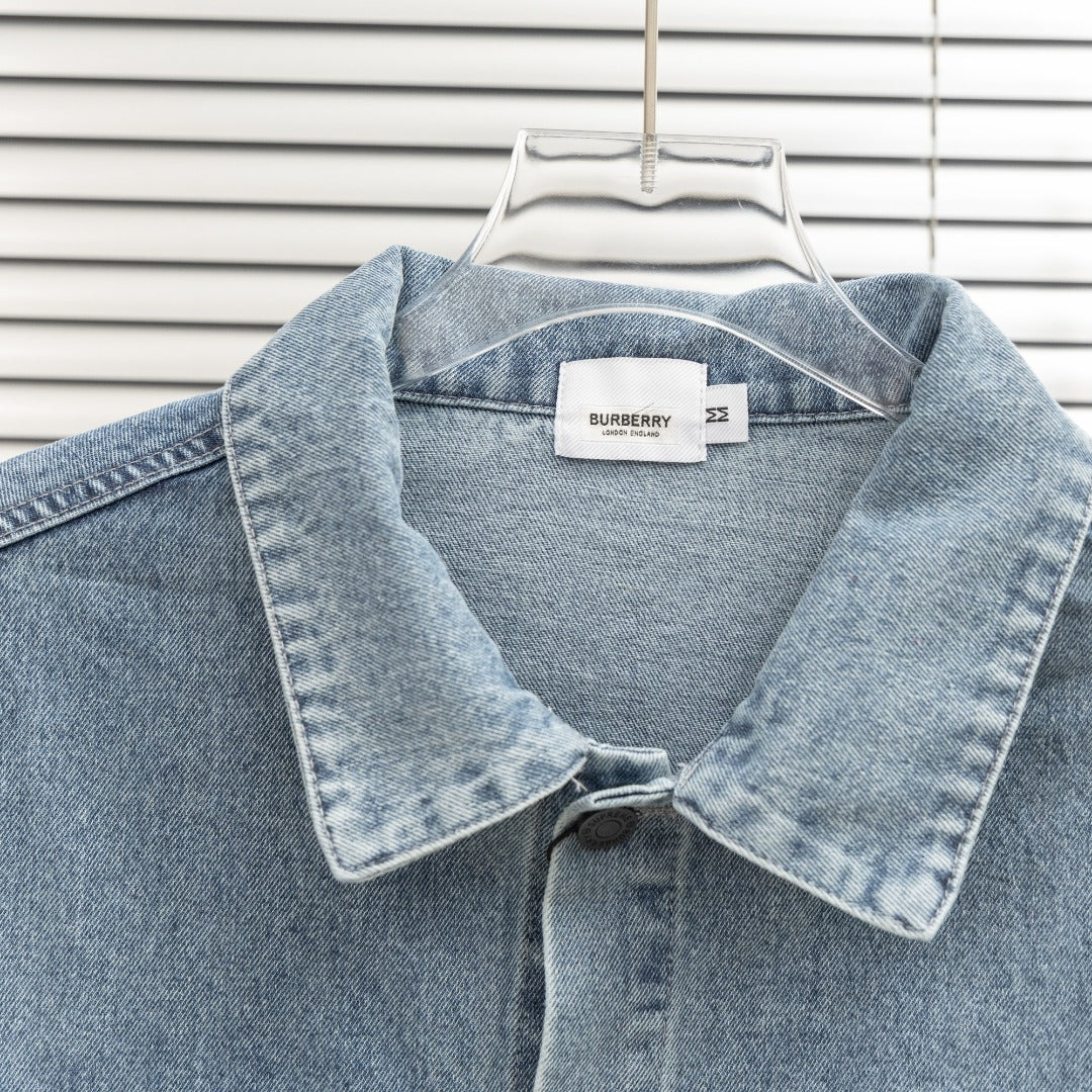Denim jacket close-up with pointed collar, snap buttons, and small Burberry label