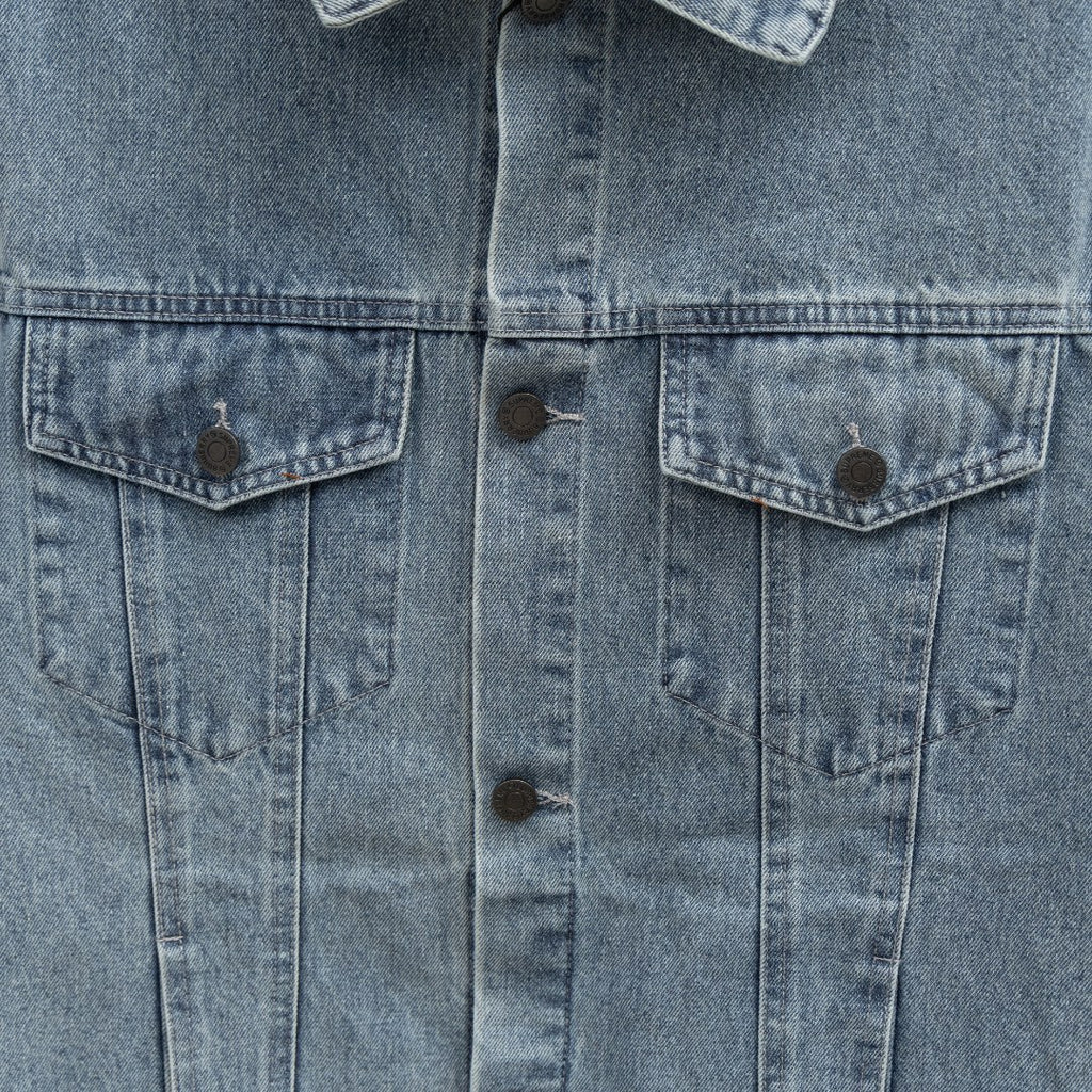 Front center close-up of long denim jacket with two chest flap pockets and buttons