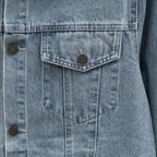 Denim jacket chest pocket close-up with buttoned flap and vertical seam stitching