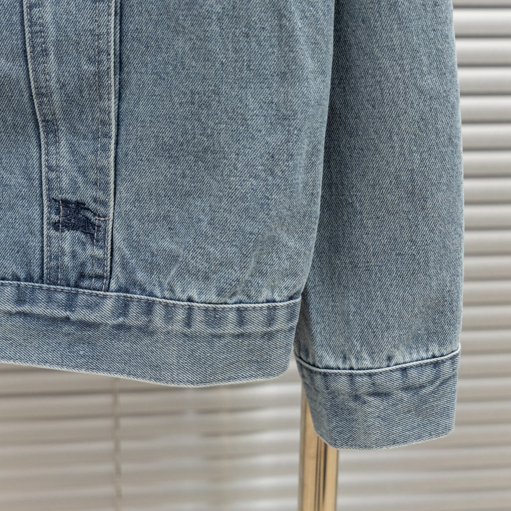 Denim jacket hem and cuff close-up with stitched edge and button detail