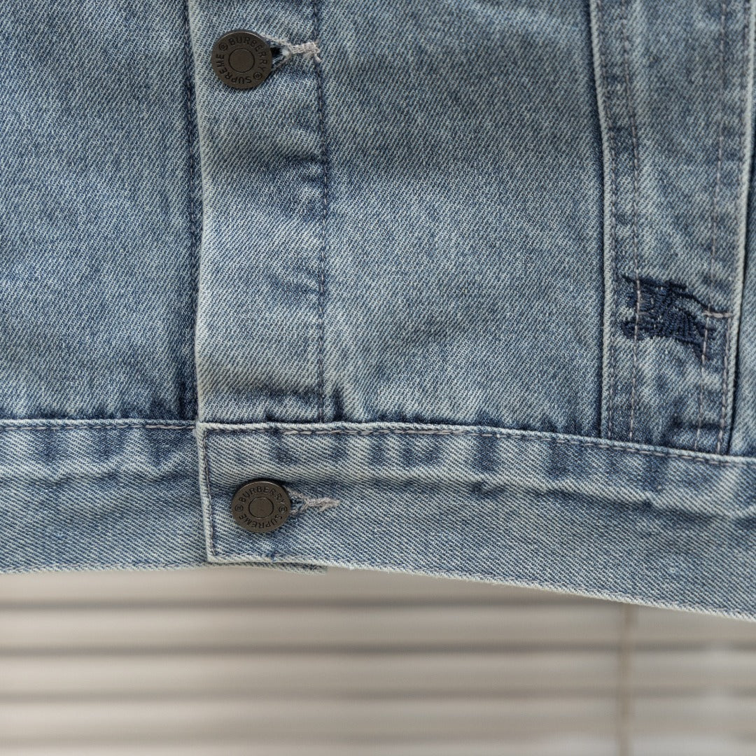 Denim jacket lower front close-up with bottom button and flap-pocket seams