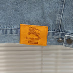 Light blue denim jacket with tan leather logo patch labeled Burberry Supreme