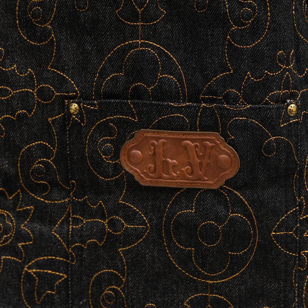 Louis Vuitton brown leather-look patch on dark denim with gold logo pattern