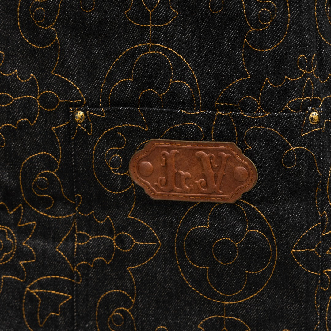 Louis Vuitton brown leather-look patch on dark denim with gold logo pattern