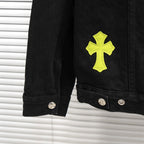 Black denim jacket sleeve with neon yellow cross patch and metal buttons