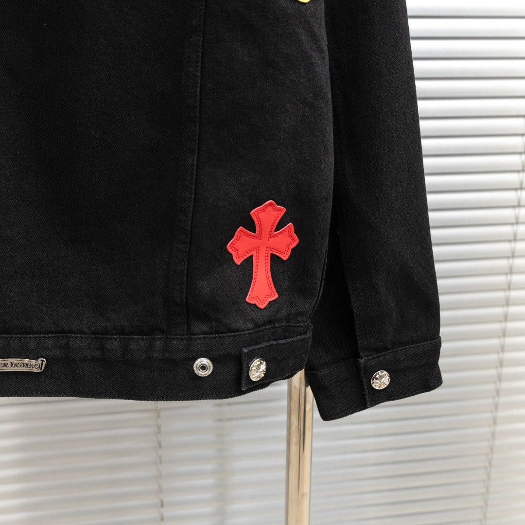 Black denim jacket sleeve with red cross patch and metal button cuff