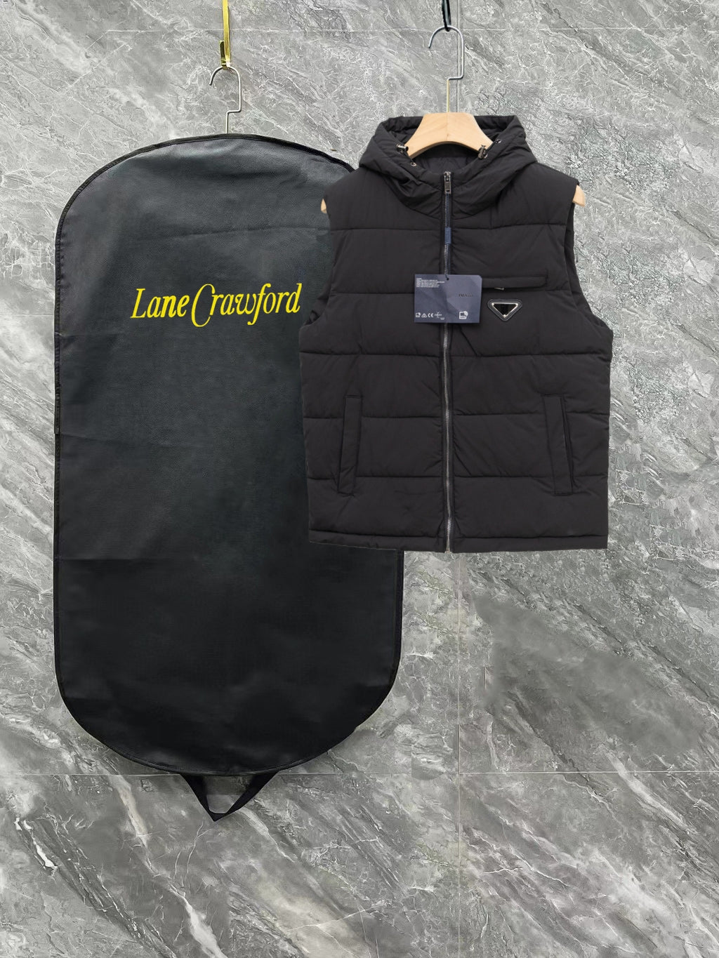 Black long padded vest with hood, front zipper, triangle logo patch