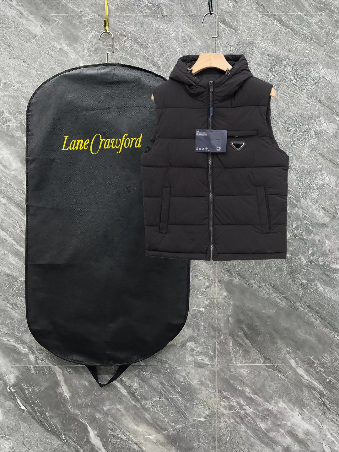 Black long padded vest with hood, front zipper, triangle logo patch