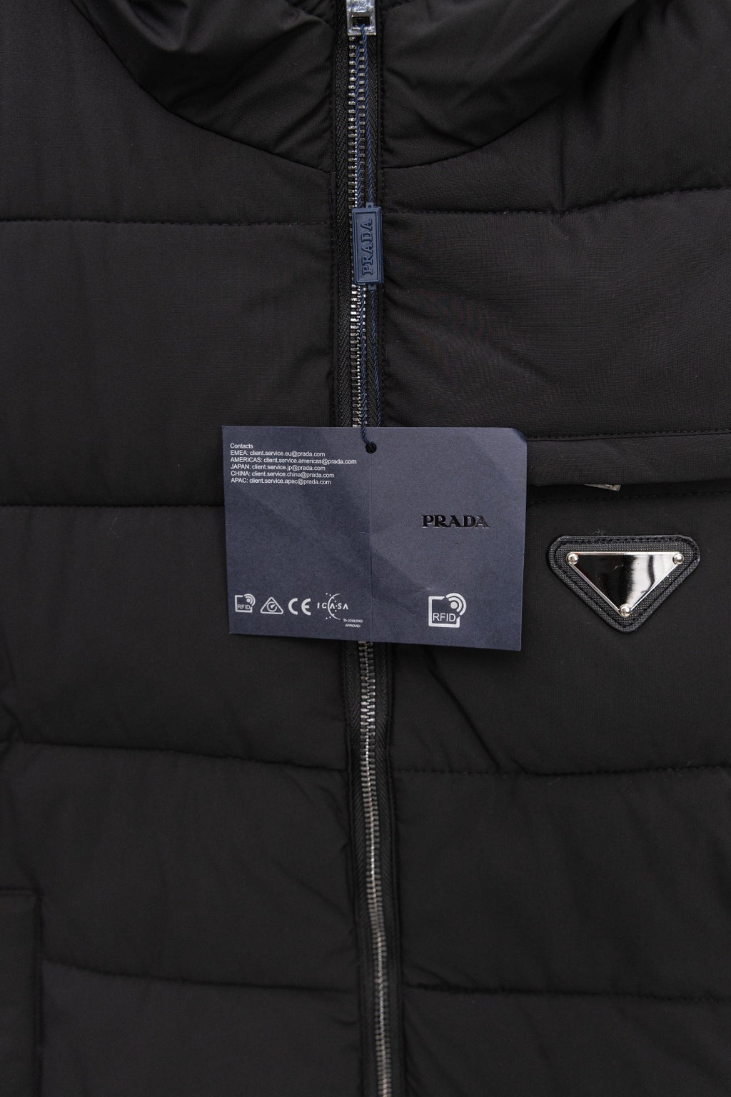 Black padded vest with center zipper and hanging tag, triangle logo