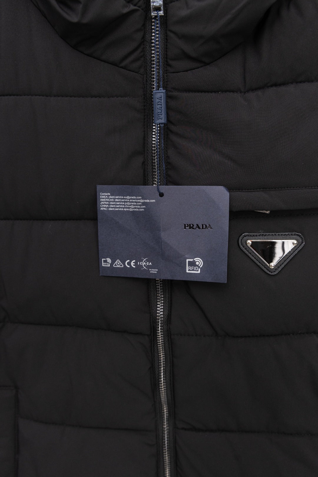 Black padded vest with center zipper and hanging tag, triangle logo