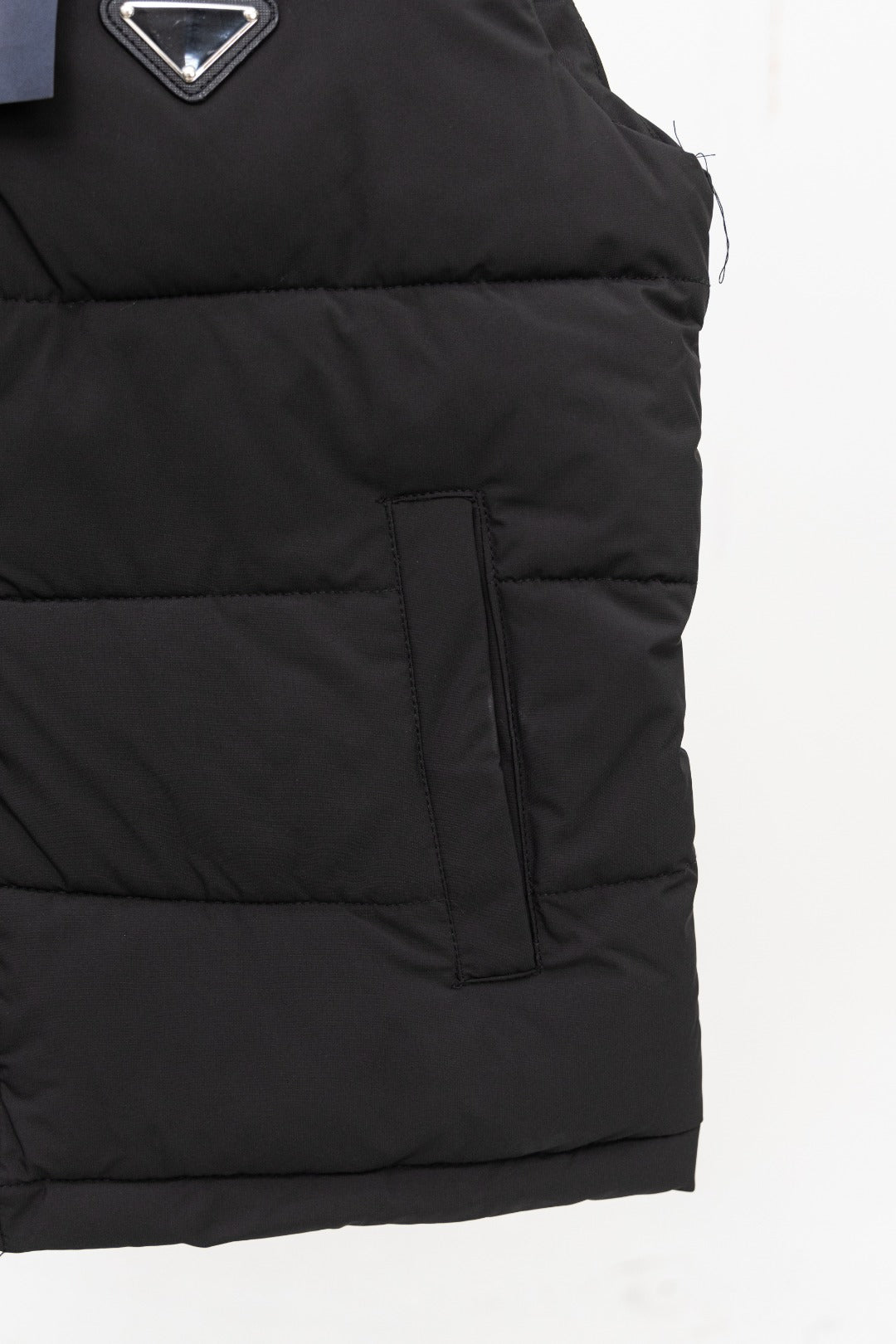 Black long padded vest with side pocket and center seam zipper