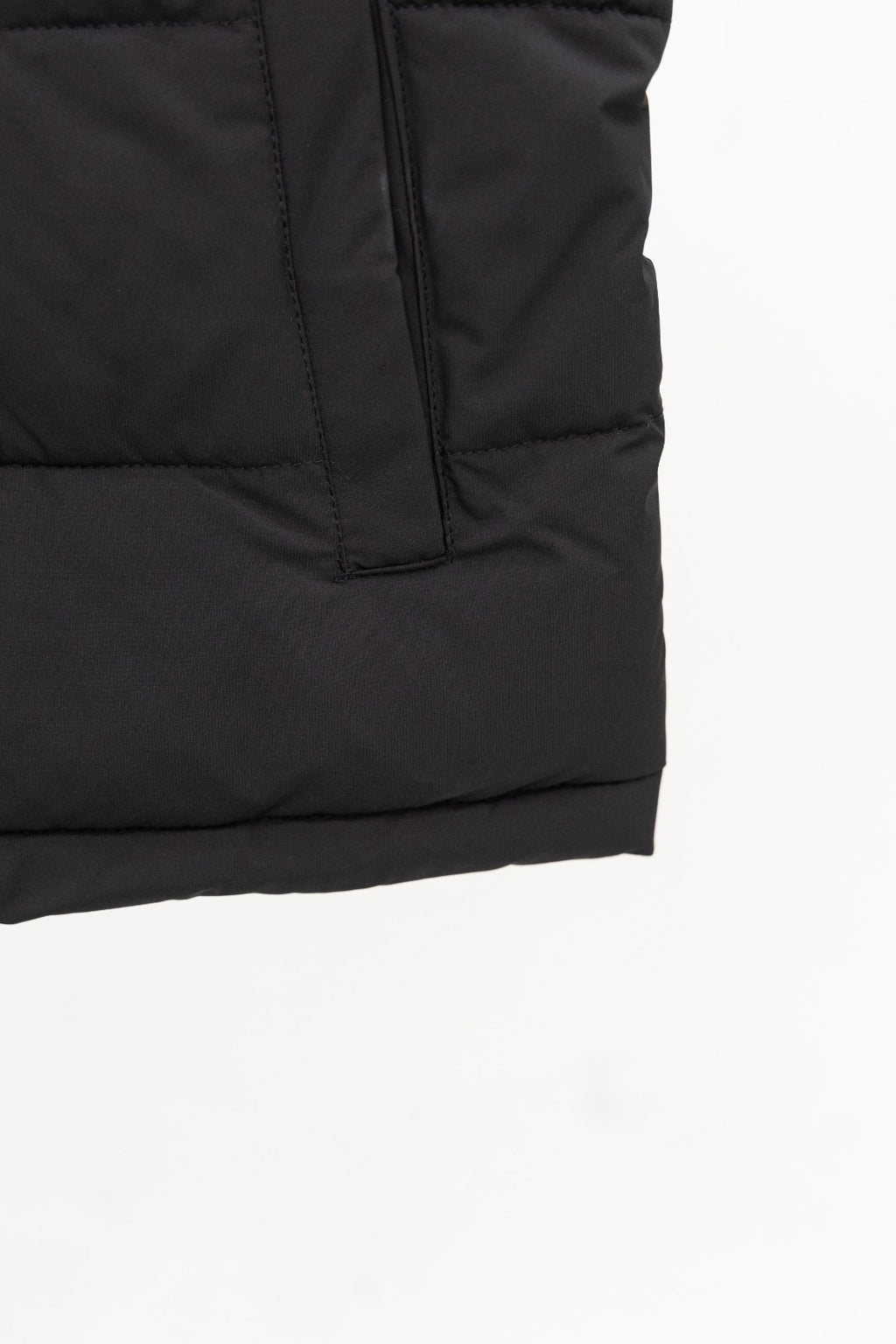 Black long padded vest hem with vertical quilt seams