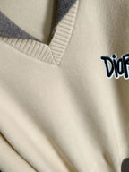 Cream sweater neckline with light blue ribbing and small Dior logo
