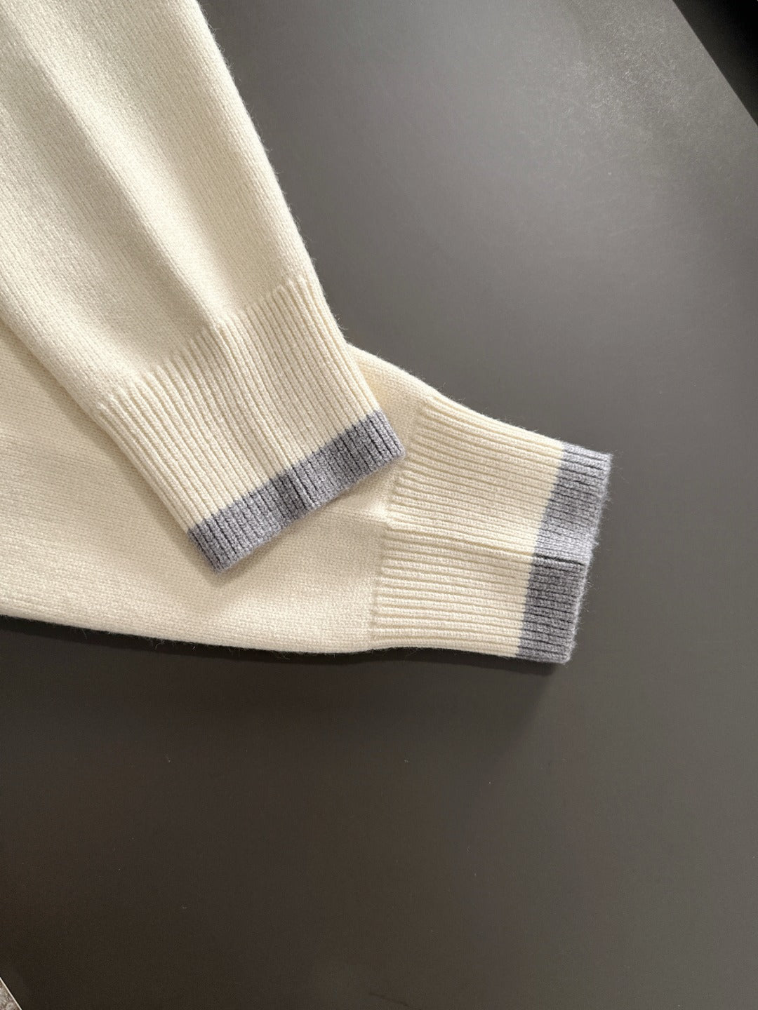 Cream sweater cuff with light blue ribbed trim on long sleeve