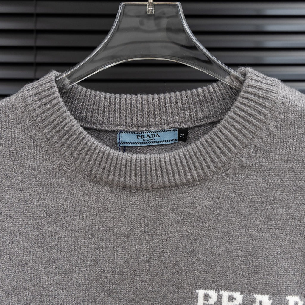 Prada knit sweater collar and PRADA Milano logo on heather gray fabric.