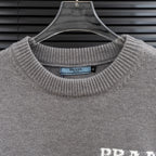 Prada knit sweater collar and PRADA Milano logo on heather gray fabric.