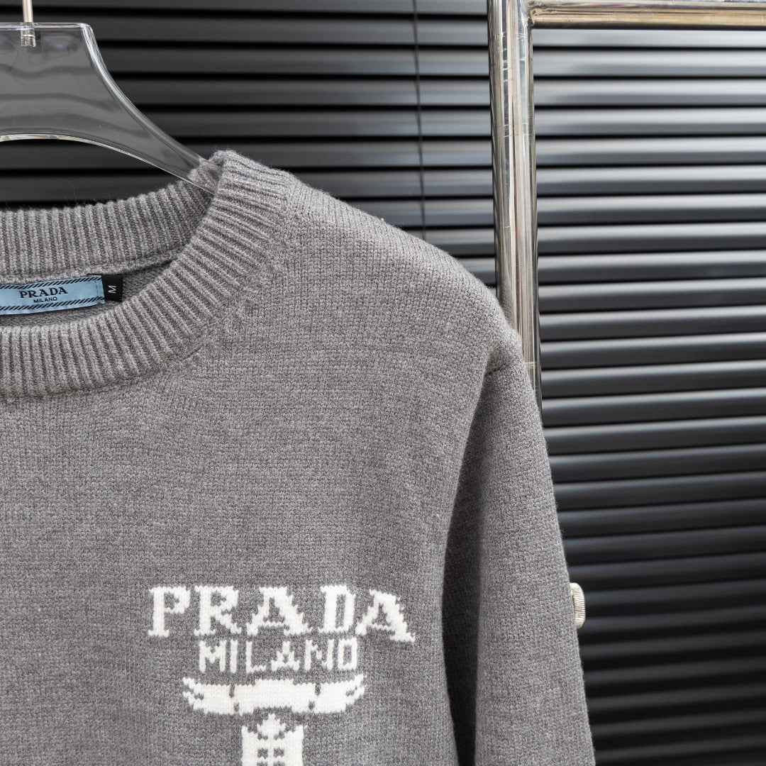 Prada heather gray sweater sleeve detail with PRADA Milano graphic on the front.