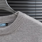 Prada heather gray knit sweater with ribbed crew neckline and fabric texture detail.