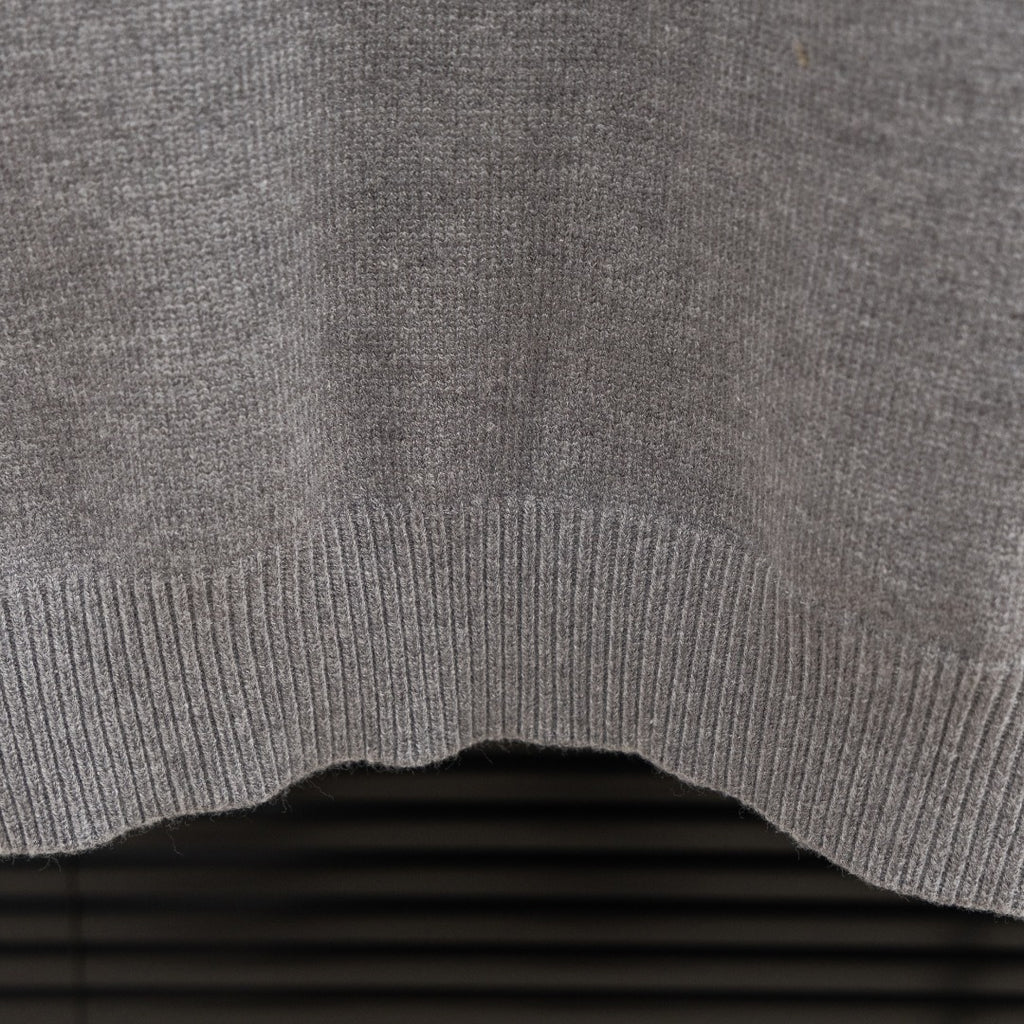 Prada heather gray sweater ribbed hem edge detail on knit fabric.