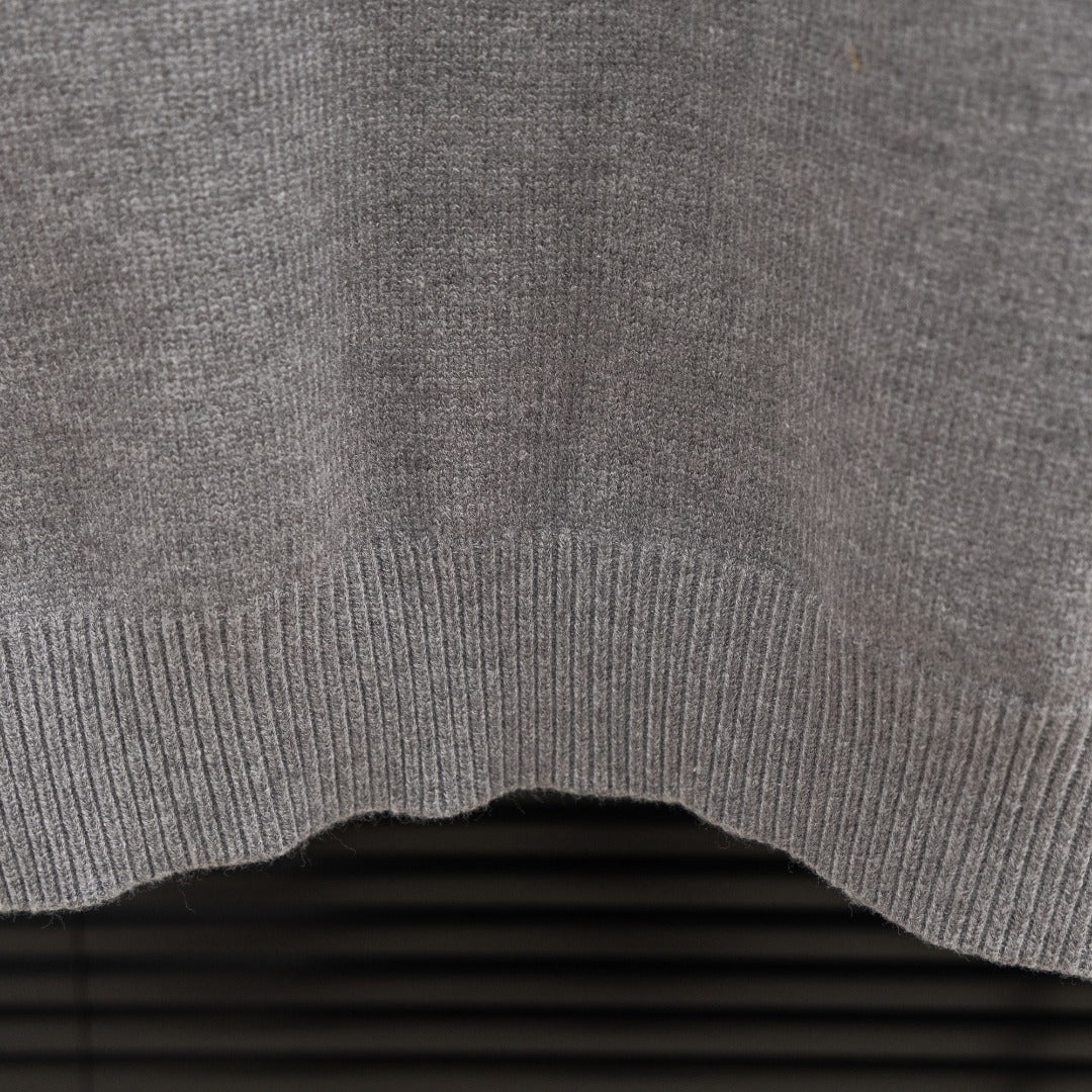 Prada heather gray sweater ribbed hem edge detail on knit fabric.