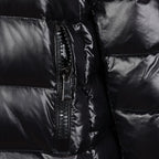 Black puffer coat close-up of front zipper and glossy quilted panels