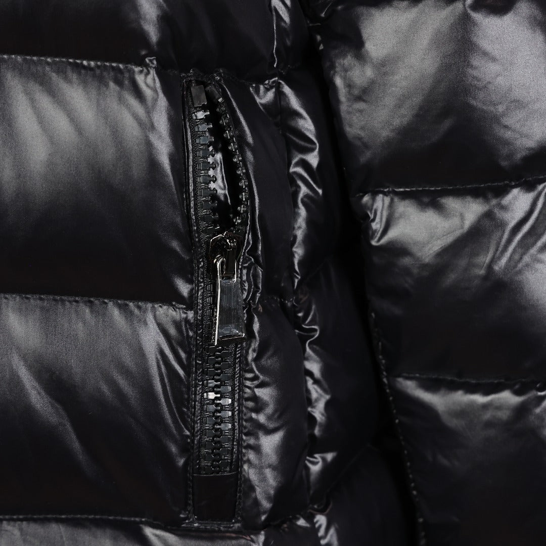 Black puffer coat close-up of front zipper and glossy quilted panels