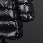 Black puffer coat sleeve cuff and lower pocket area with quilted baffles
