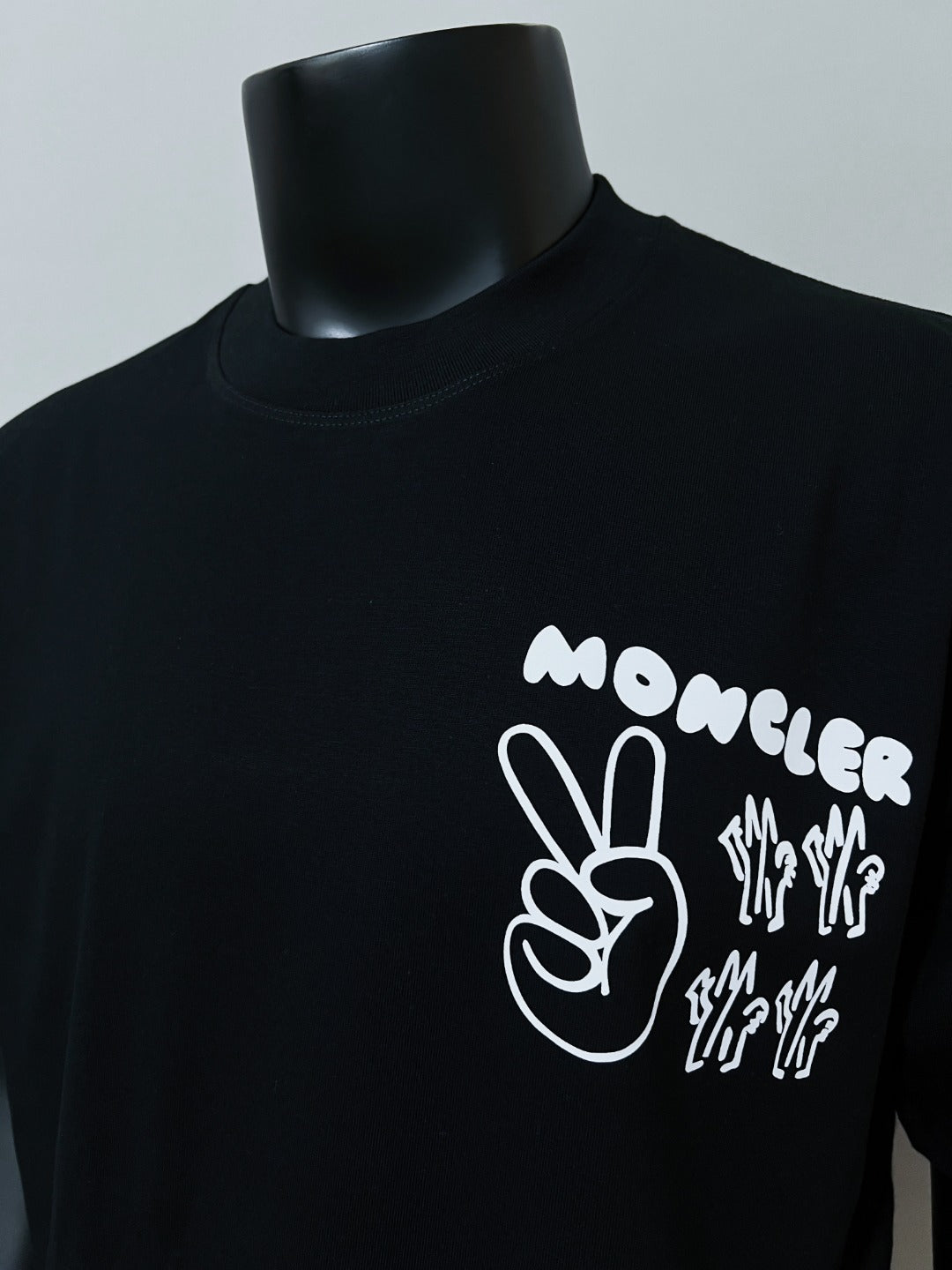Dark navy short-sleeve T-shirt with white Moncler hand and text graphic