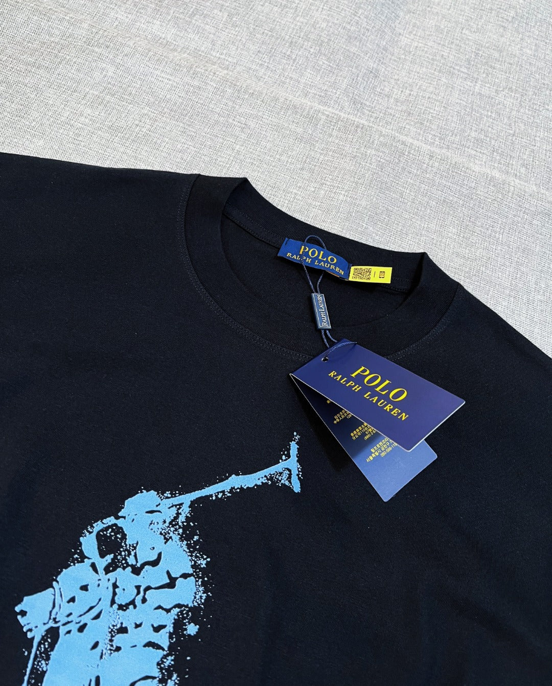 Polo Ralph Lauren black T-shirt neckline with woven brand tag and blue graphic