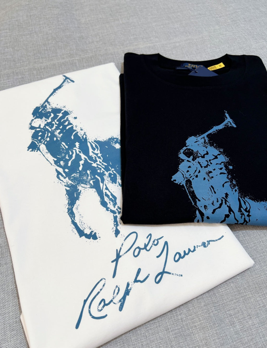 Polo Ralph Lauren folded black T-shirt with blue polo player graphic on top