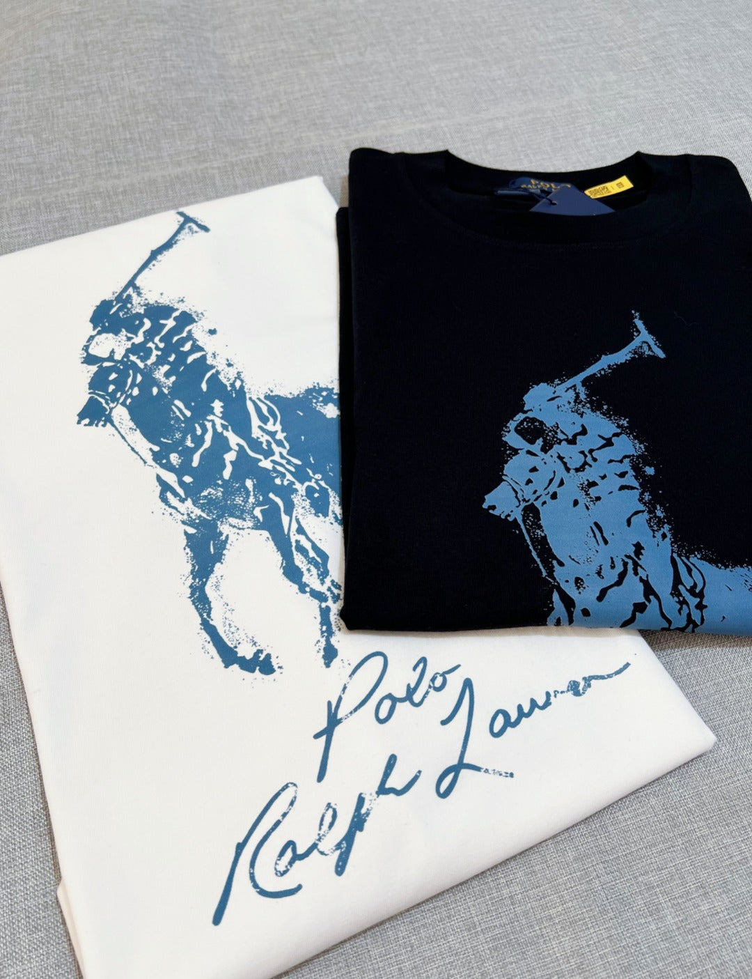 Polo Ralph Lauren folded black T-shirt with blue polo player graphic on top