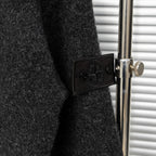 Stone Island sleeve patch detail with embossed logo on dark charcoal knit