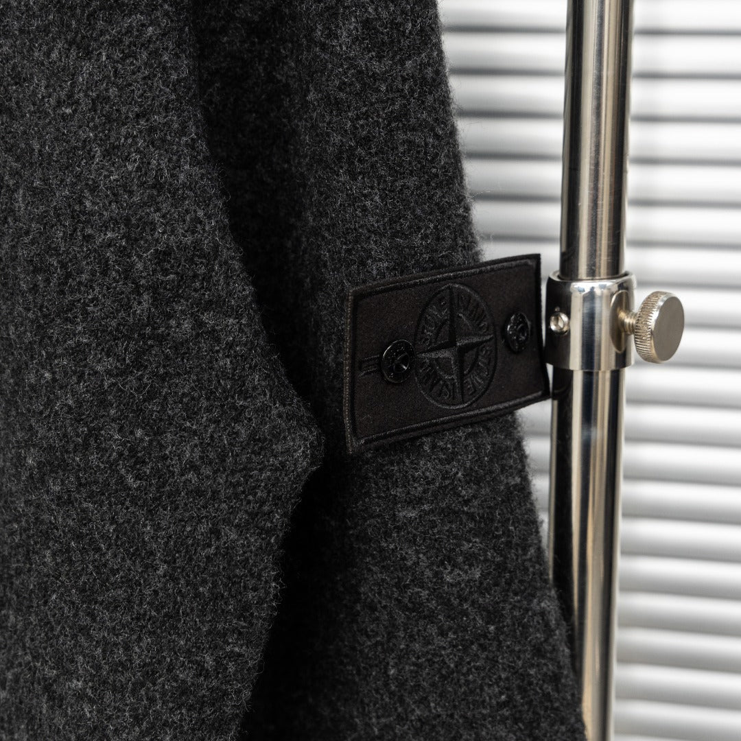 Stone Island sleeve patch detail with embossed logo on dark charcoal knit