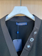 Long-sleeve V-neck sweater with chest patches and hanging tag, dark tone
