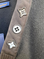 Close-up of sweater side trim with star and flower Louis Vuitton patches