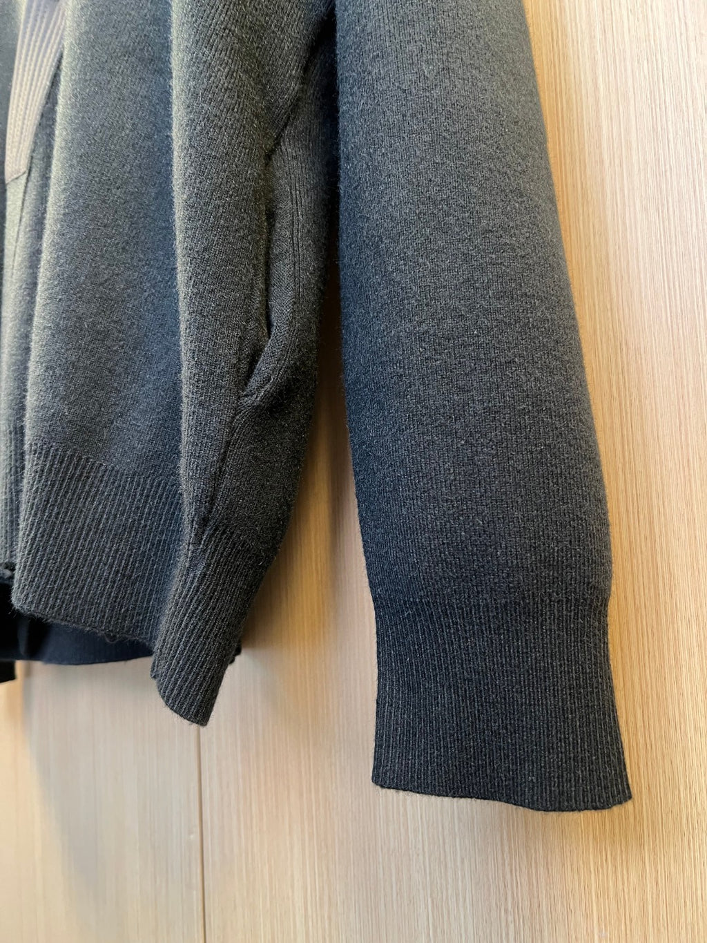 Dark-tone knit sweater sleeve and cuff detail