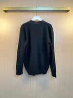Back view of dark long-sleeve sweater on hanger
