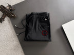 Black Gucci pants folded view with elastic waistband and red logo patch