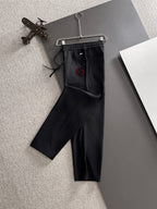 Black Gucci pants with elastic drawstring waist and red logo emblem
