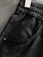 Black Gucci pants close-up of curved pocket seam and metal button