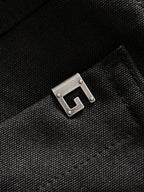 Black Gucci pants fabric detail with metal buckle-like hardware