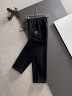Black drawstring pants with elastic waistband and embroidered crest