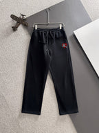 Black drawstring pants with elastic waistband and embroidered crest on thigh