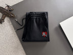 Black lounge pants with elastic waistband, drawstring cords, and crest
