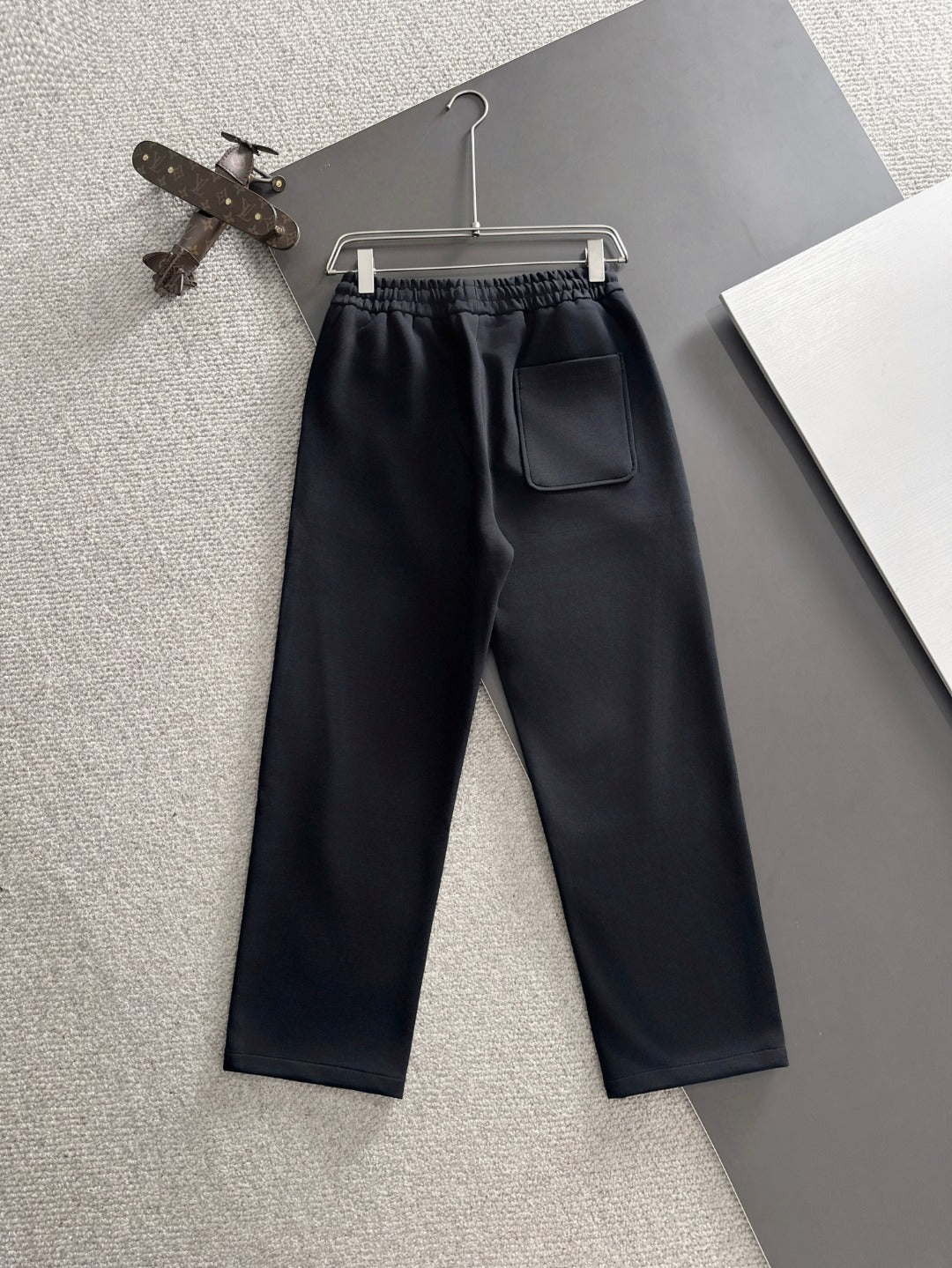 Black pants with elastic waistband, front crease, and side pocket
